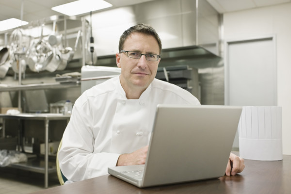 Chef working on laptop in kitchen. Date : 2008