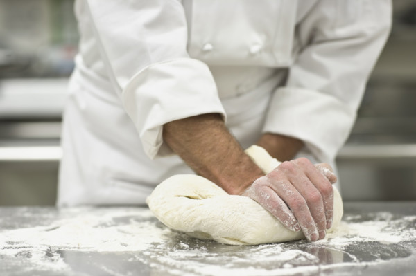 Baker kneading bread dough. Date : 2008