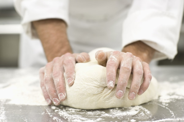 Baker kneading bread dough. Date : 2008