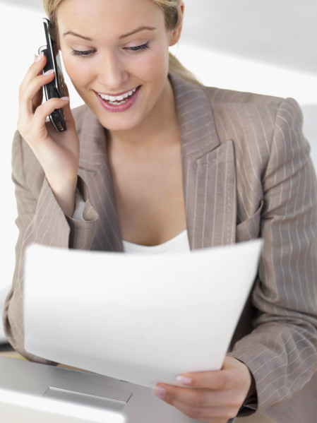 Businesswoman discussing paperwork on cell phone. Date : 2008