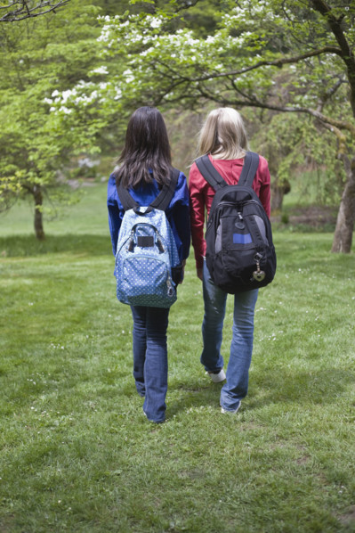 Girls with backpacks walking in park. Date : 2008