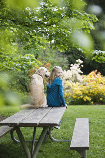 Girl and dog sitting on park bench. Date : 2008