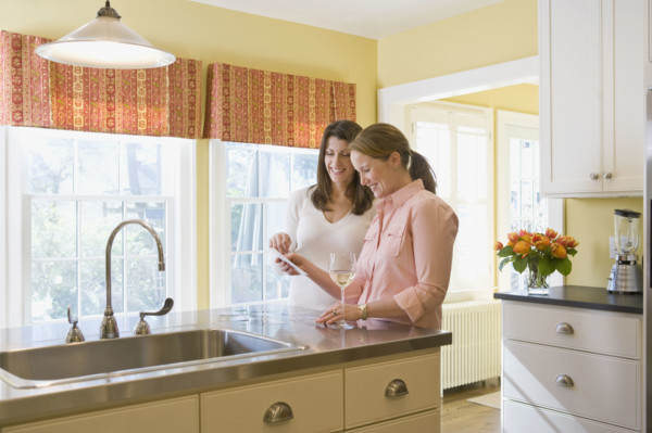 Friends looking at photographs in kitchen. Date : 2008