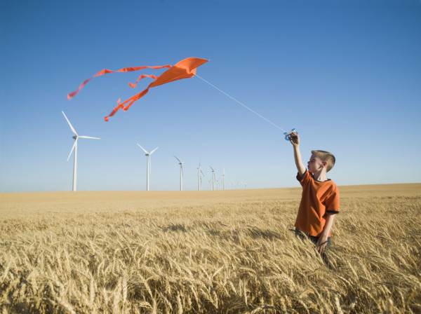 Boy running with kite on wind farm. Date : 2008