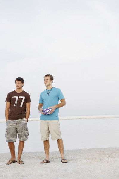 Young men standing on beach with football. Date : 2008