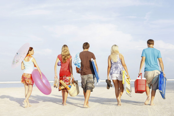 Friends walking with beach essentials. Date : 2008
