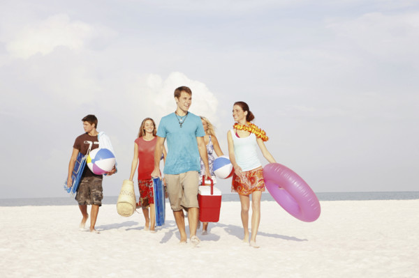 Friends walking with beach essentials. Date : 2008