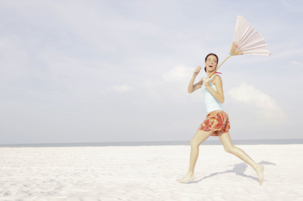 Girl running on beach with umbrella. Date : 2008