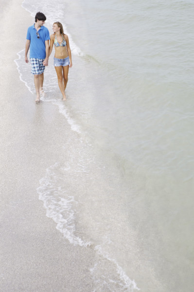 Teenage couple walking in ocean. Date : 2008