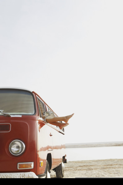 Feet sticking out of van window on beach. Date : 2008