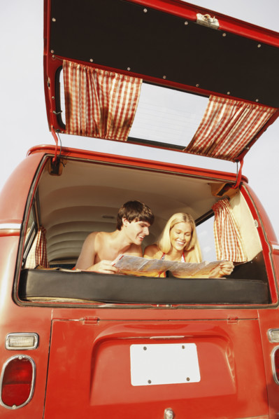Teenage couple relaxing in van on beach. Date : 2008
