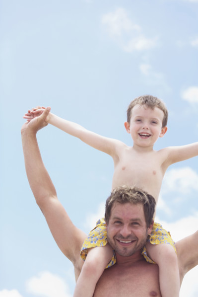 Father carrying son on shoulders. Date : 2008
