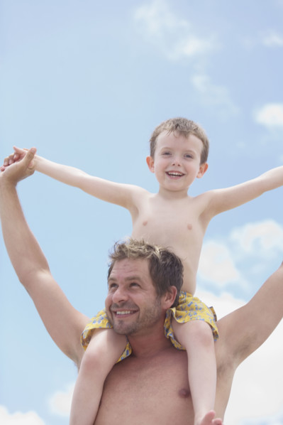 Father carrying son on shoulders. Date : 2008