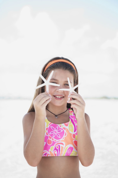 Girl on beach holding delicate starfish. Date : 2008