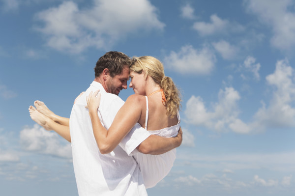 Man carrying girlfriend on beach. Date : 2008