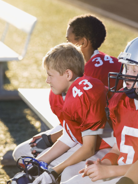Football players sitting on bench. Date: 2008