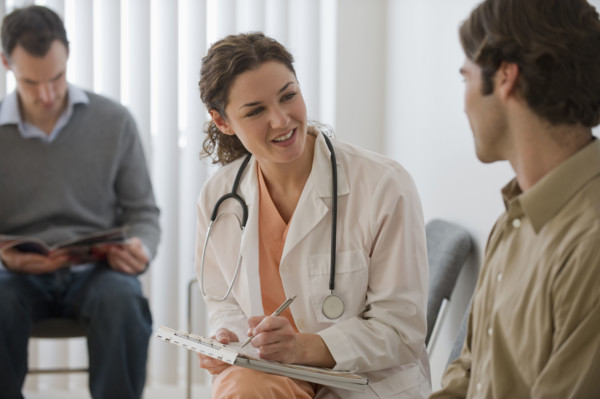 Female doctor in waiting room with male patient.