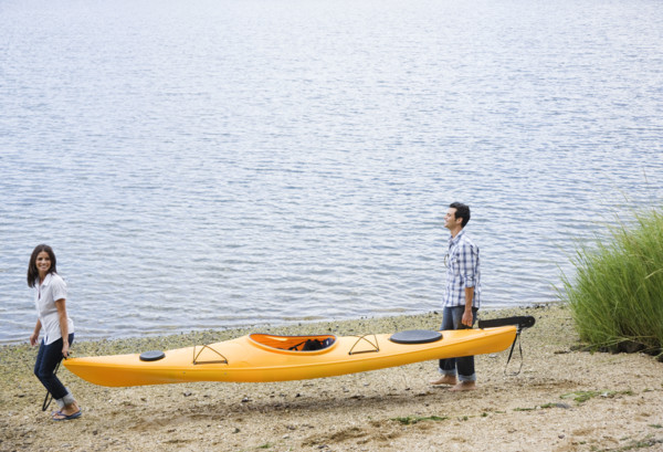 Couple carrying kayak. Date: 2008