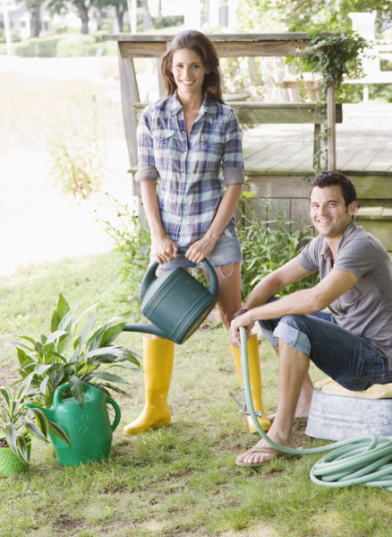 Couple watering plants in backyard. Date : 2008