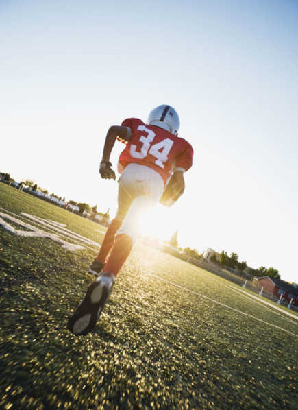 Football player running on field with football. Date : 2008