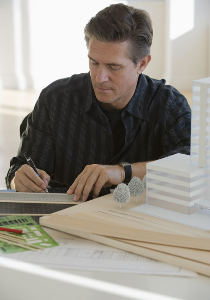 Architect working on building model.
