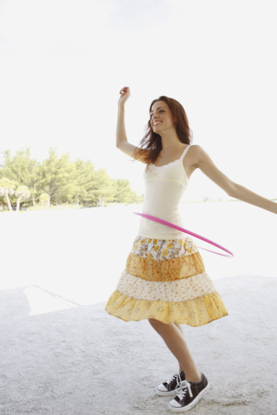 Woman on beach with hula hoop. Date: 2008