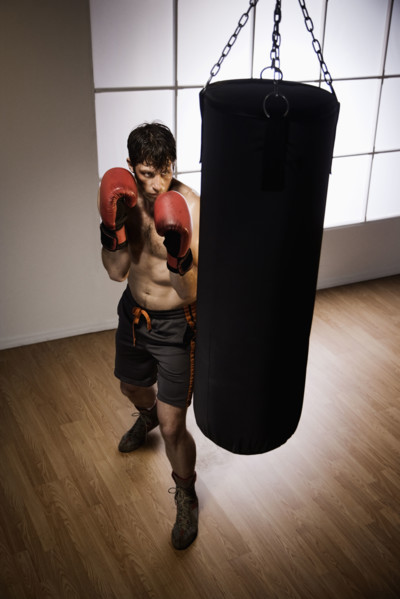 Boxer training with punching bag. Date : 2008