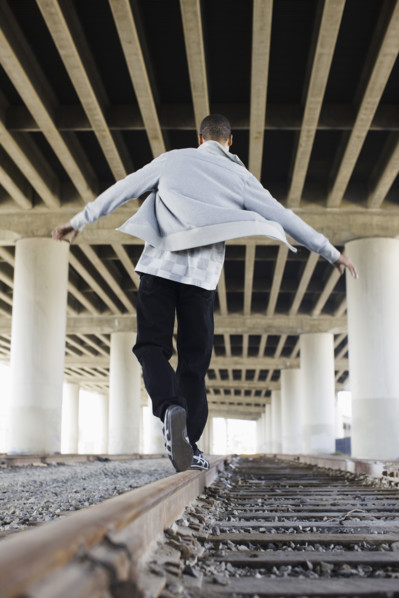 Man balancing on railroad tracks. Date: 2008