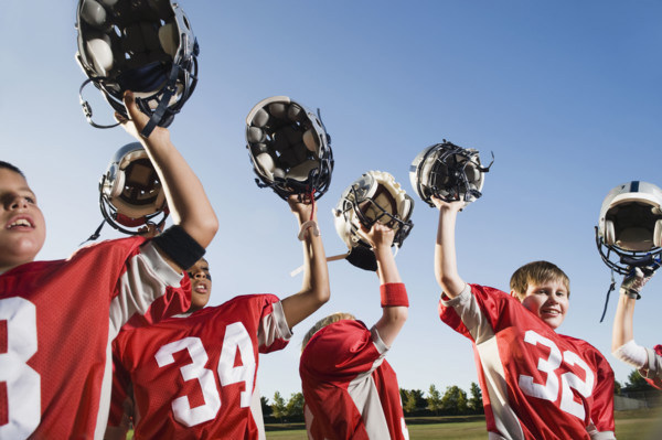 Football team holding helmets overhead. Date: 2008