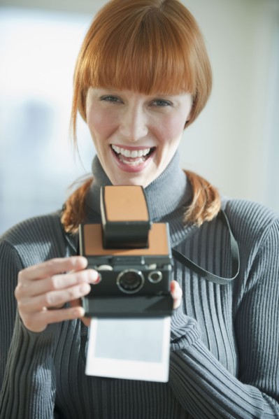 Woman holding vintage camera.