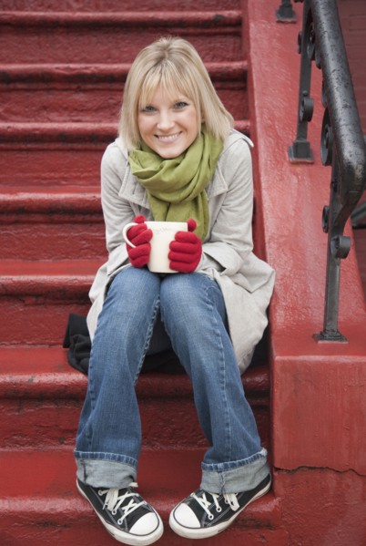 Woman drinking hot chocolate on front stoop. Photographe : Jamie Grill