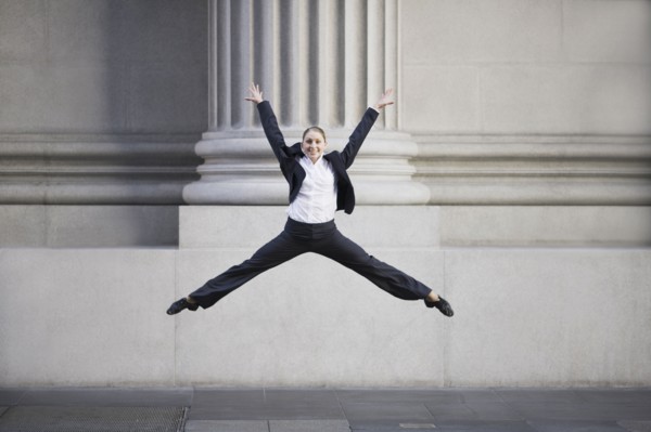 Businesswoman dancing in urban setting. Photographe : PT Images