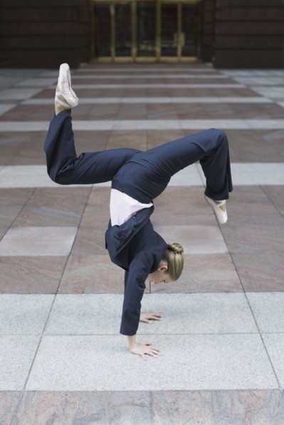 Businesswoman dancing in urban setting. Photographe : PT Images