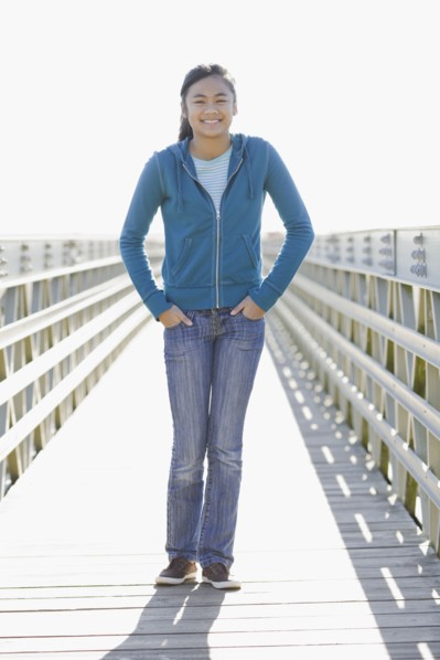 Teenage girl standing on dock. Photographe : PT Images