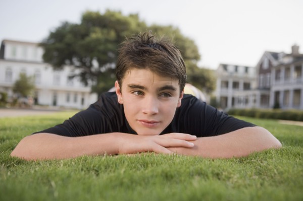 Teenage boy in grass. Photographe : mark edward atkinson