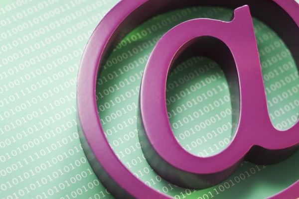 Close up of “at’ symbol and binary code.
