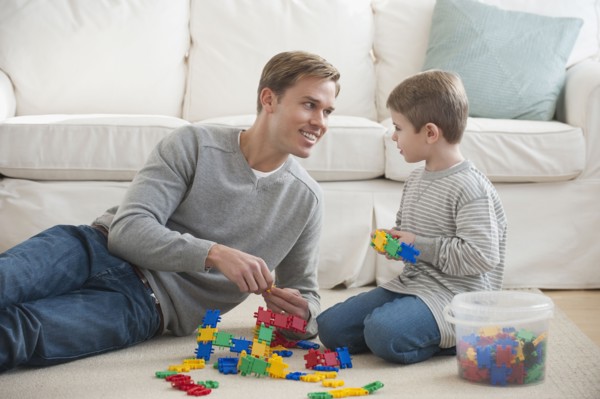 Father playing with son in livingroom.