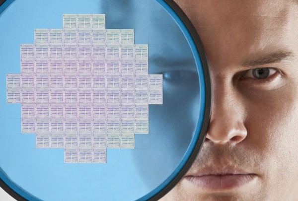Close up of man looking through computer chip.