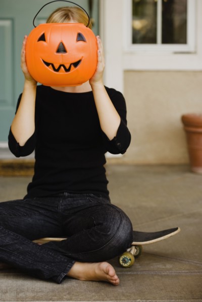 Girl holding plastic jack-o-lantern bucket. Photographe : Sarah M. Golonka