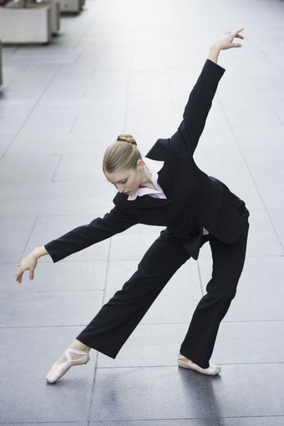 Businesswoman dancing in urban setting. Photographe : PT Images