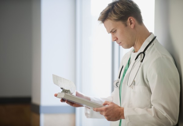 Doctor reading medical chart.