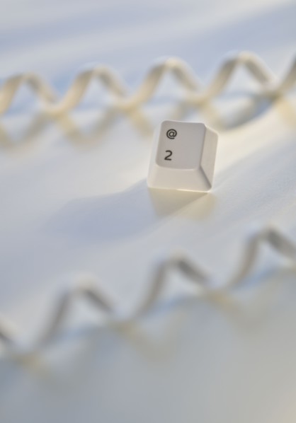 Close up of telephone cord and computer key.