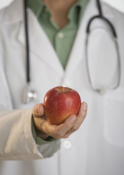 Doctor holding apple.