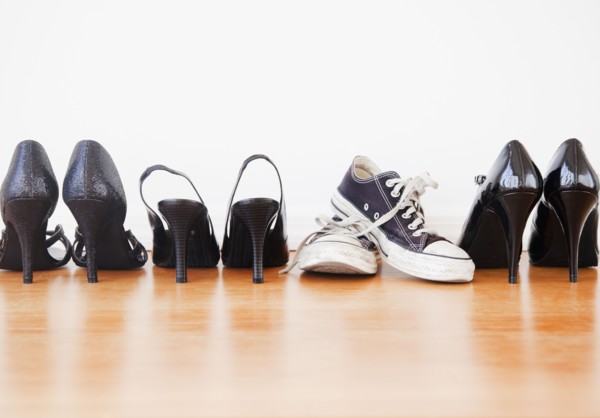 Canvas shoe in row of elegant high heel shoes. Photographe : Jamie Grill