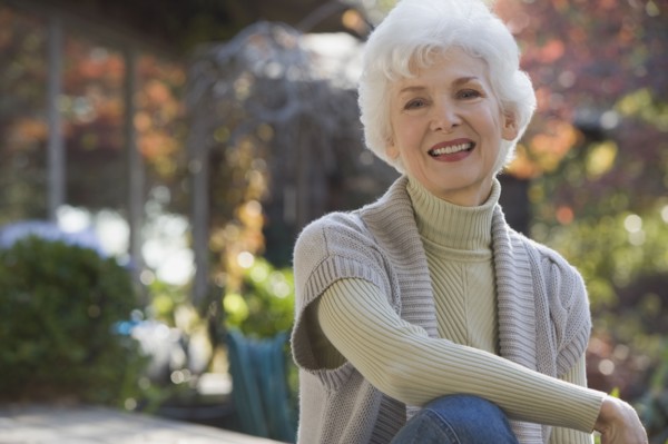 Portrait of senior woman sitting in garden. Photographe : mark edward atkinson