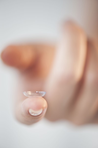 Close-up of contact lens on woman's finger.