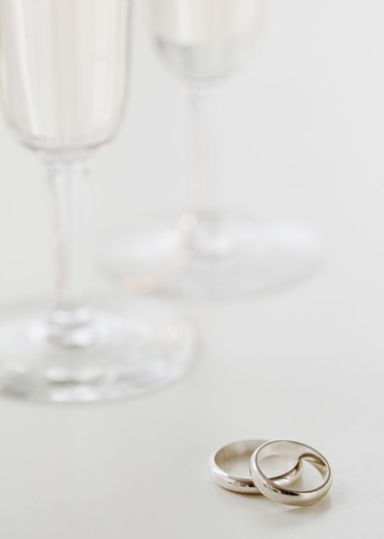Two wedding rings by wineglasses. Photographe : Jamie Grill