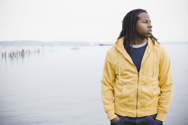 Teenage boy (16-17) with dreadlocks, standing at waterfront, San Francisco, California, USA.