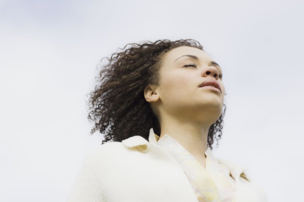 Young woman with eyes closed, outdoors. Photographe : PT Images