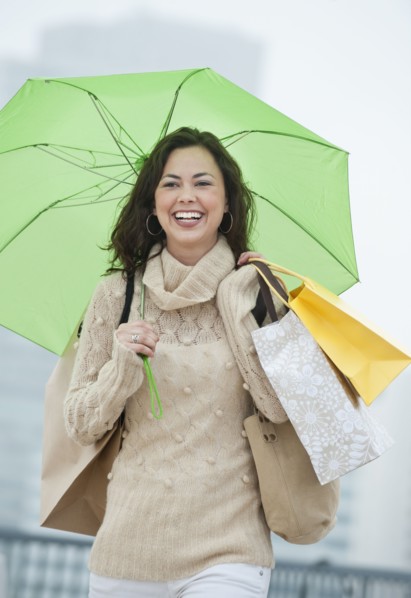 A woman with shopping bags in the rain.